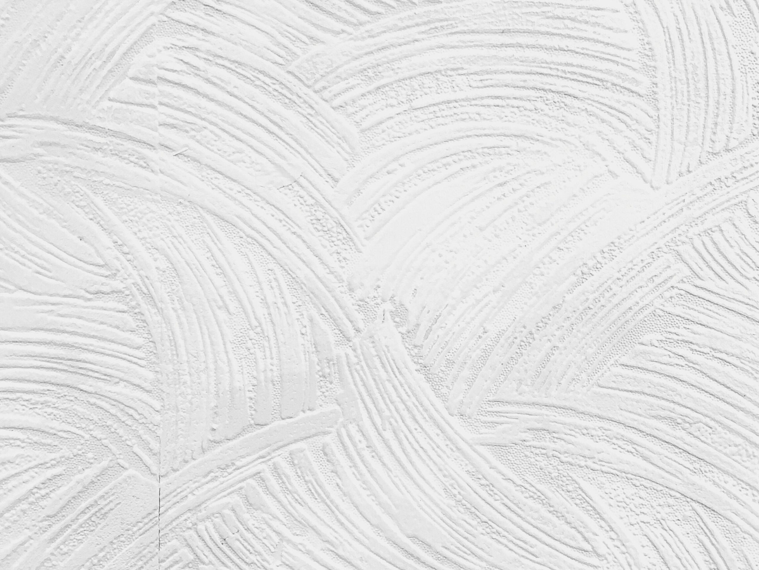 Minimalistic textured white plaster wall ideal for backgrounds and designs.